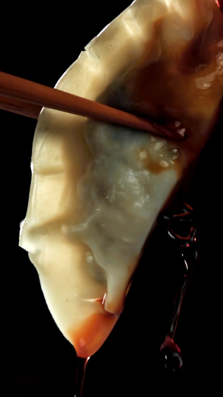 Soy Sauce Dripping from a Dumpling Held by Chopsticks