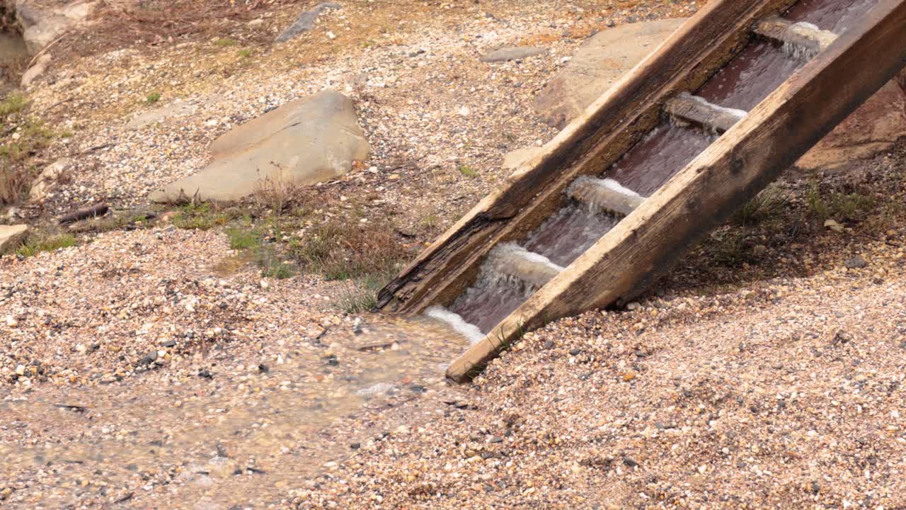Water flows down a wooden chute