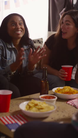 Video-Vertical-De-Amigos-En-Casa-Riendo-Hablando-Y-Comiendo-Bocadillos-Celebrando-En-Fiesta-Haciendo-Brindis-Con-Alcohol-2