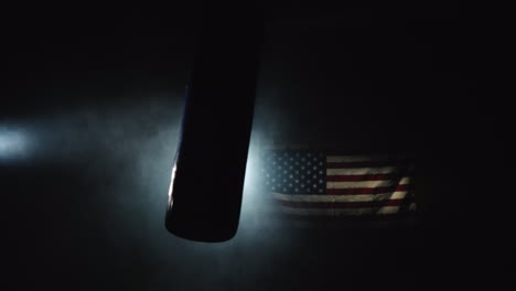 A-Boxing-Pear-Swings-In-The-Hall-In-The-Fog-And-Spotlight-In-The-Background-Of-The-US-Flag-4k-Video