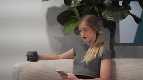 Woman-sipping-coffee-and-texting-in-cafe