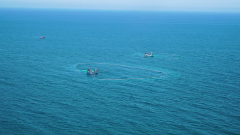 Two-fishing-boats-catch-fish-on-coast-of-Vietnam,-zoom-in