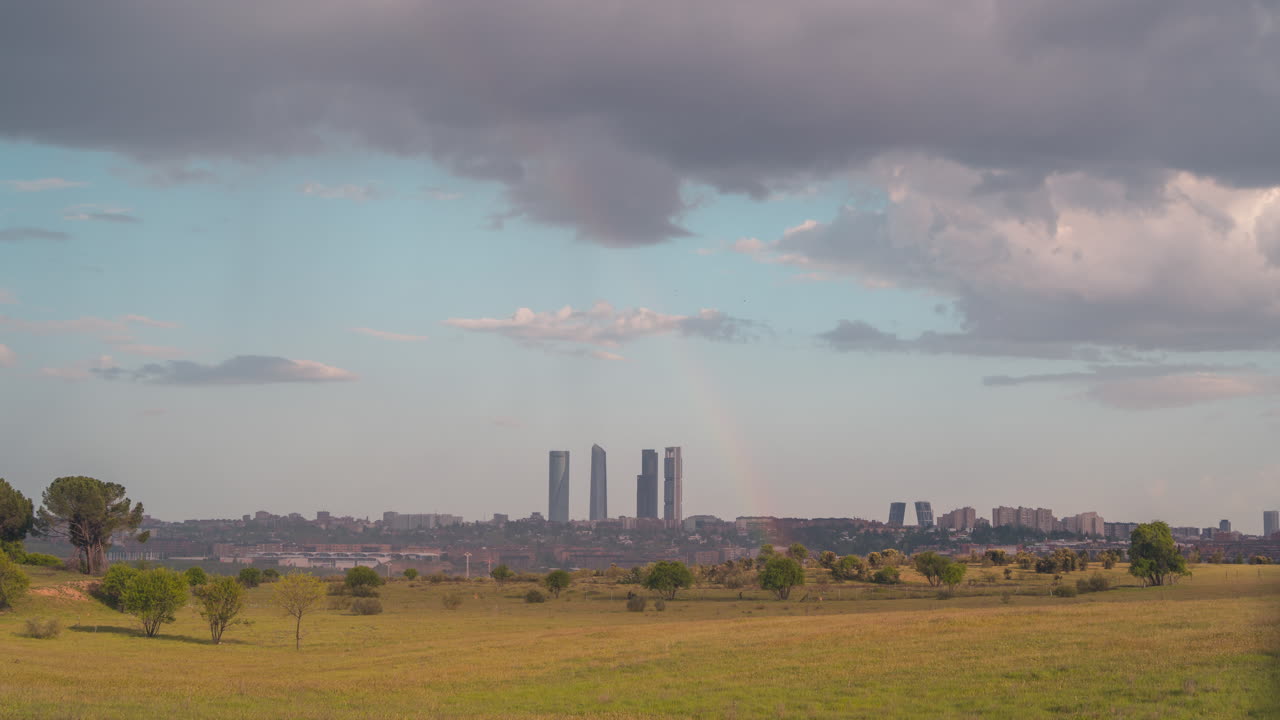 horizonte de madrid con lluvia y arco iris durante la puesta de sol.