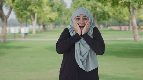 happy muslim woman getting a big surprise in park