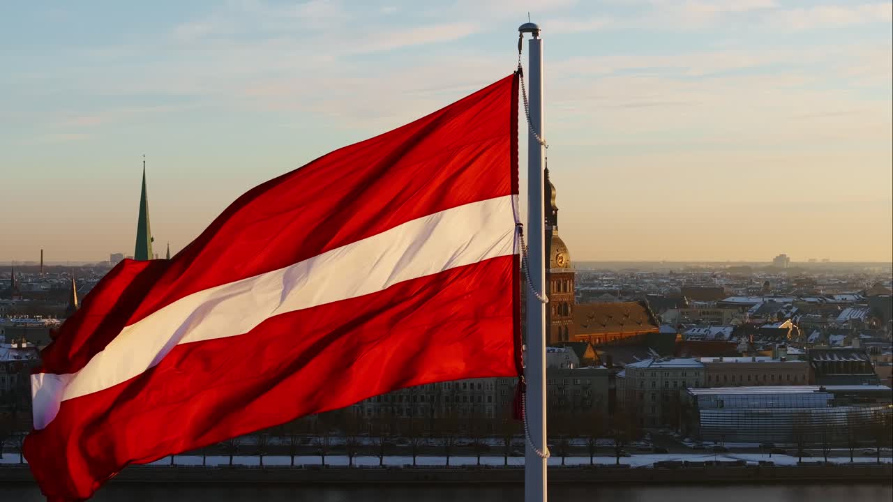 Winter Dawn Illuminates Riga Skyline with Latvian Flag Gracefully in Foreground