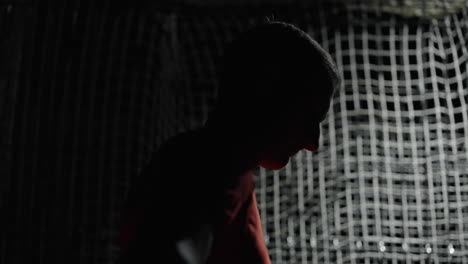 silhouette of a man in a red shirt, dark scene, and net