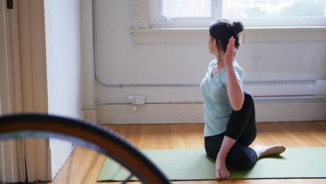 Young-woman-practicing-yoga-on-exercise-mat-4k-