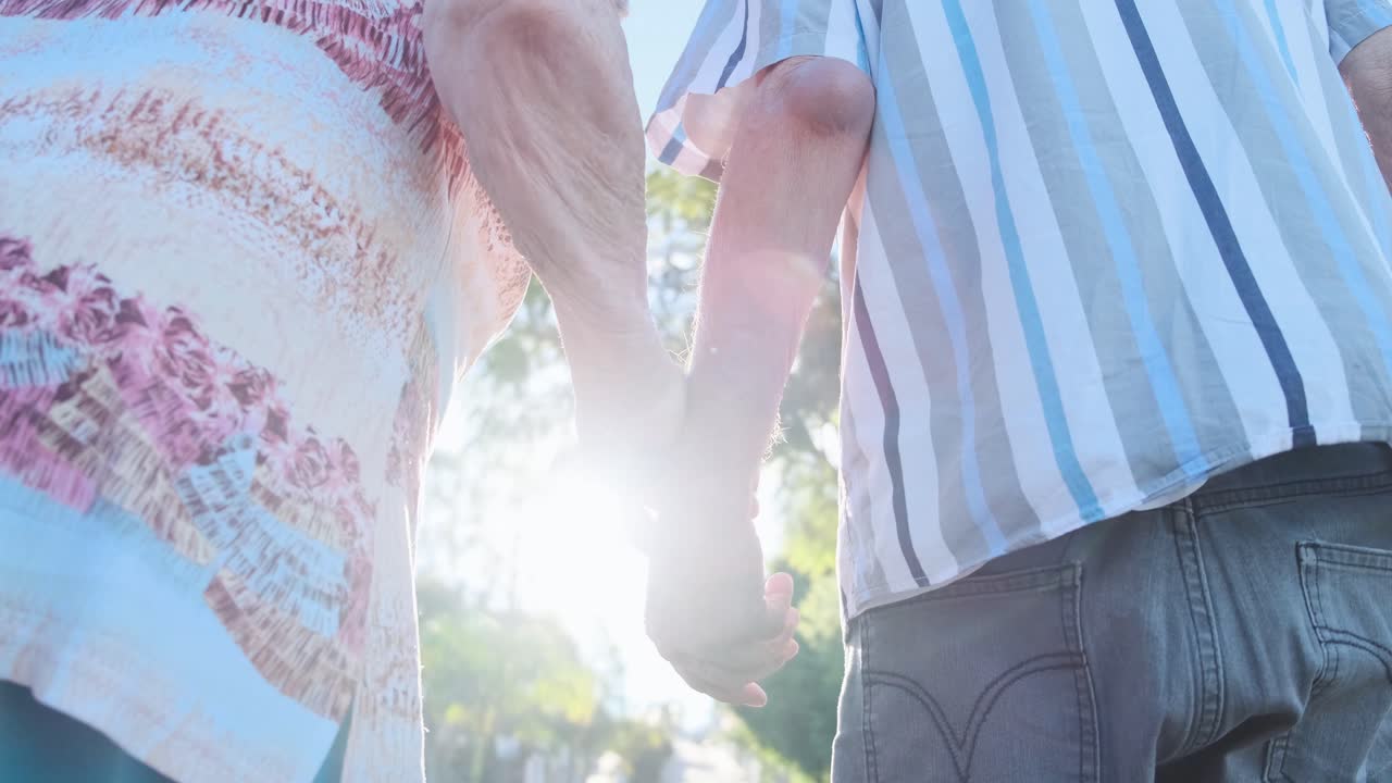 Elderly couple holding hands in a loving relationship