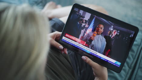 woman watching election news on tablet