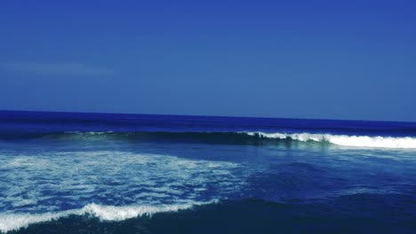 Luftaufnahmen,-Die-Mit-Einer-Drohne-Gefilmt-Wurden,-Mit-Blick-Auf-Den-Strand-Und-Das-Meer-Aus-Tosenden-Wellen-Mit-Einem-Tiefblauen-Ozean-Auf-Der-Klippe-In-Der-Südlichen-Hemisphäre-Afrikas