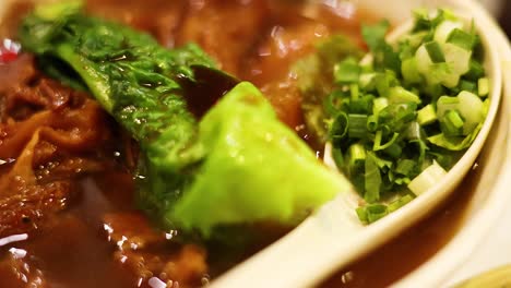 delicious noodle soup with meat and greens