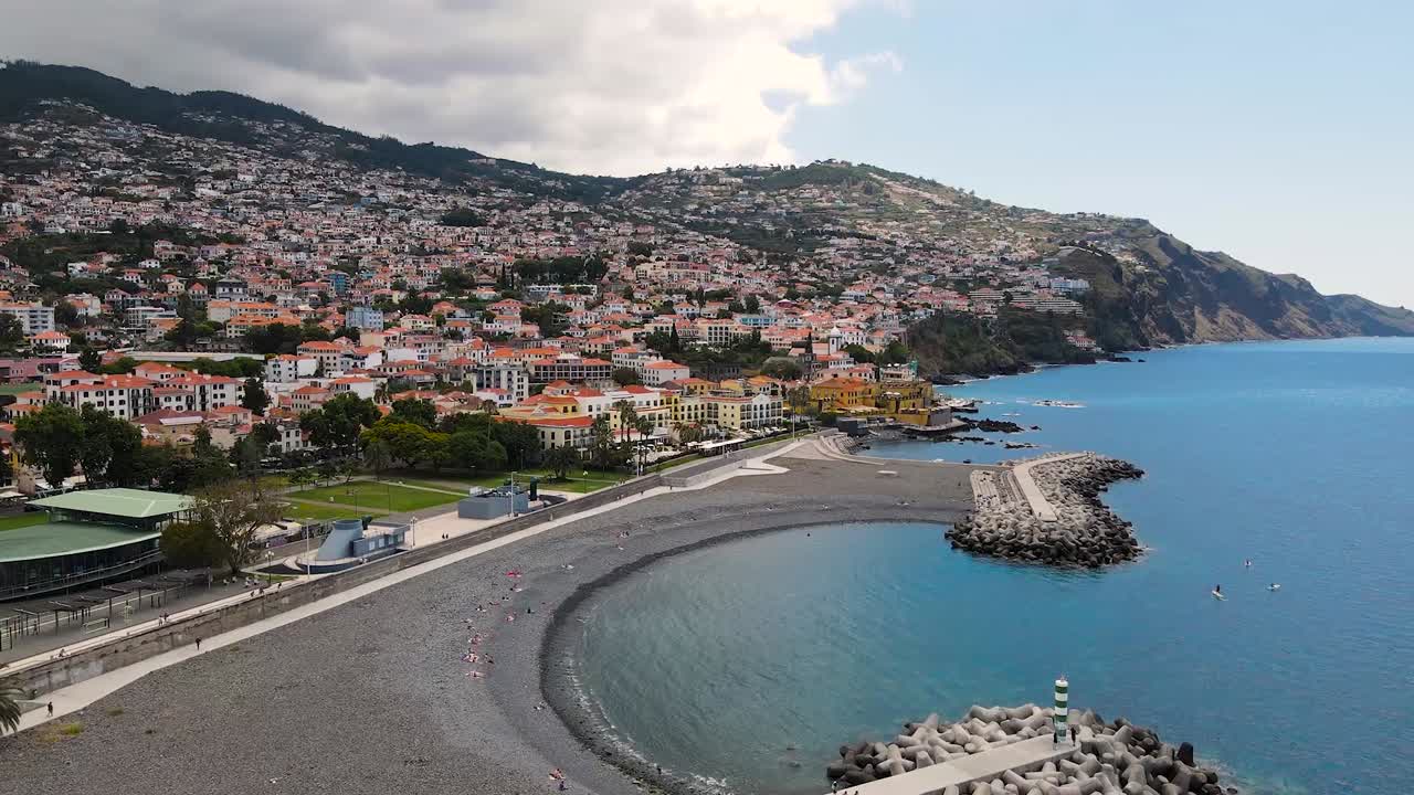 Veduta aerea del paesaggio urbano e turisti sdraiati sulla spiaggia a Funchal, Madeira, Portogallo