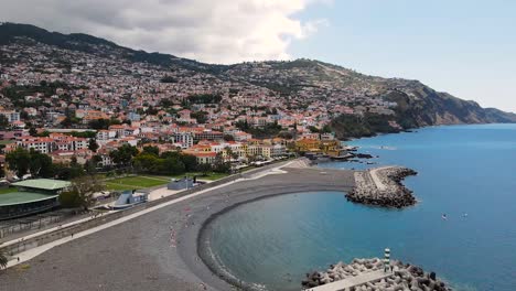 aerial view of the city landscape and tourists lying on the beach in funchal, madeira, portugal