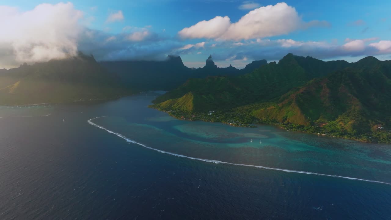 Sunset Cooks Opunohu bay Moorea French Polynesia aerial drone bright blue lagoon coral reef Mount Mauaroa Tohivea Rotui jagged mountain peaks Haapiti Paopao South Pacific Ocean windy static shot