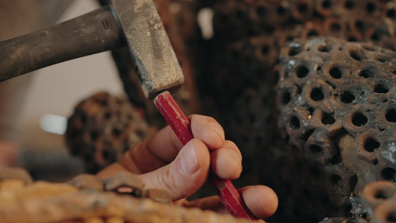 close up of hand crafting detail with red wax and carved surface