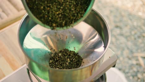 seeds being poured into oil press machine