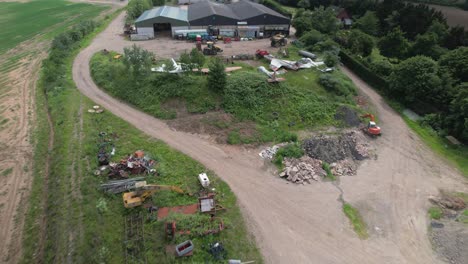 aerial establishing shot of the vintage military jets graveyard in the rural area in worcestershire, uk