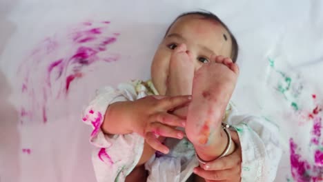 infant-paying-holi-in-traditional-dress-with-colors-from-top-angle
