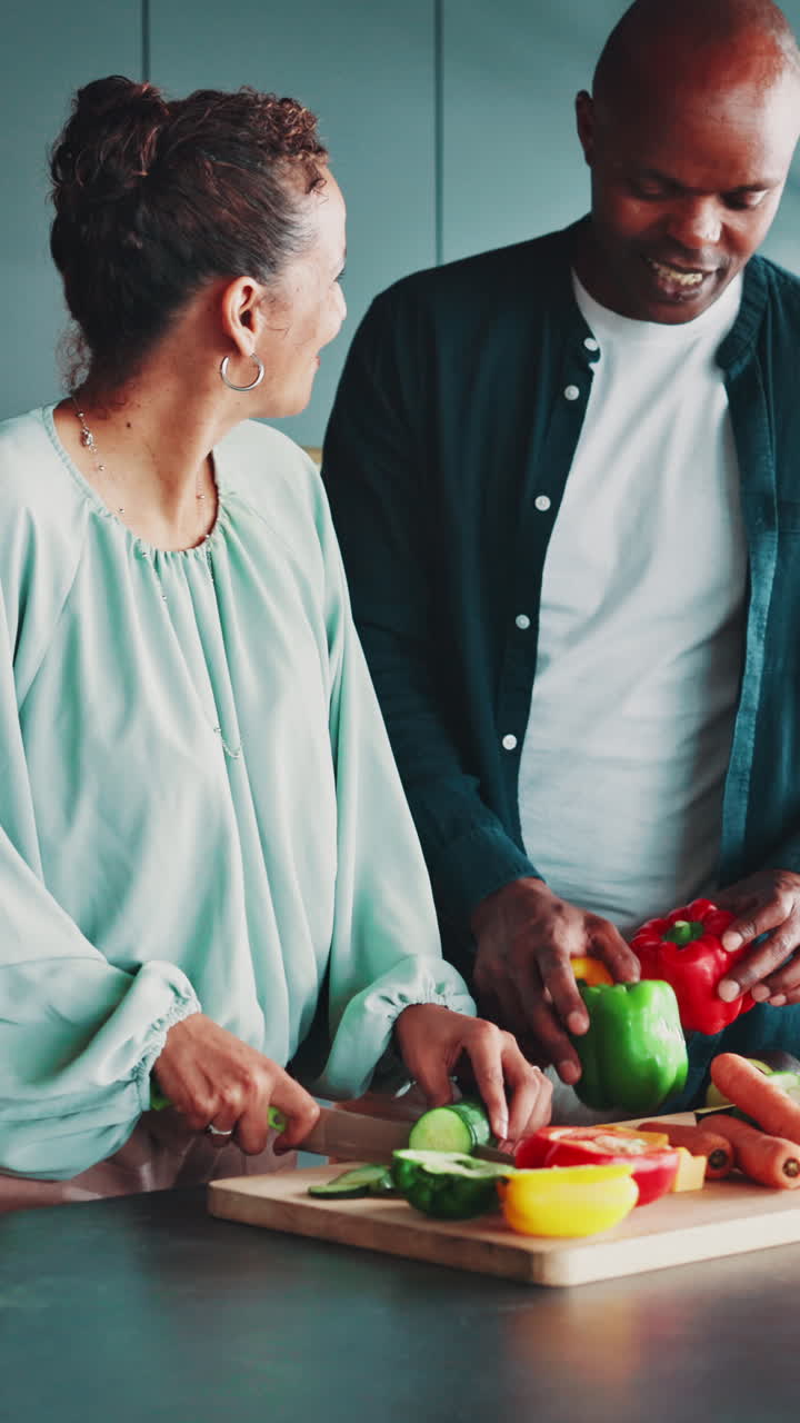Coppia felice che taglia verdure fresche insieme in una cucina moderna