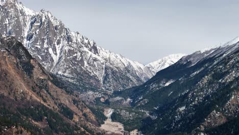 una toma aérea de un dron que destaca el encanto de la aldea de sangla con el río baspa fluyendo a través de ella.