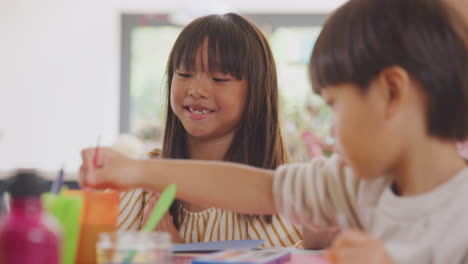 Asiatischer-Vater-Hat-Spaß-Mit-Kindern,-Die-Zu-Hause-Auf-Dem-Tisch-Basteln