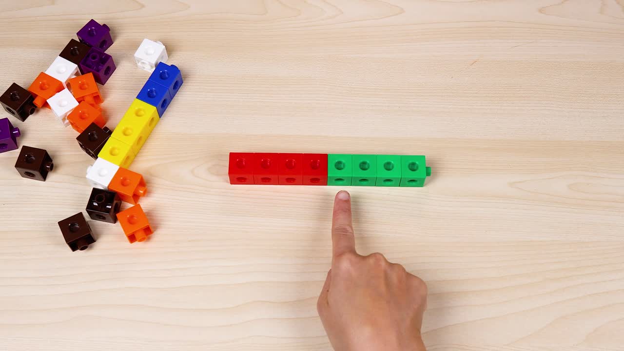 손으로 테이블 위에 다채로운 연결 큐브를 배열