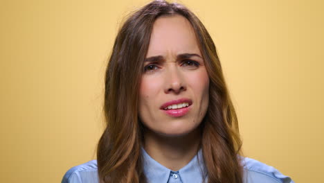 Business-woman-gesturing-on-yellow-background.-Disappointed-woman-portrait