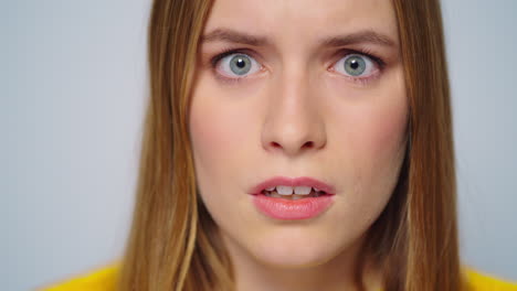 Closeup-shocked-attractive-woman-looking-at-camera-on-grey-background.