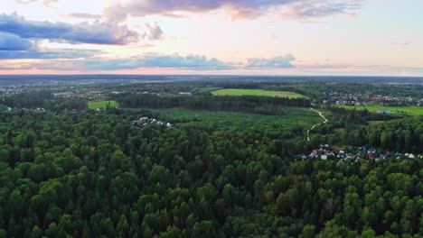 volando sobre bosques de hoja ancha y pequeños pueblos después del atardecer