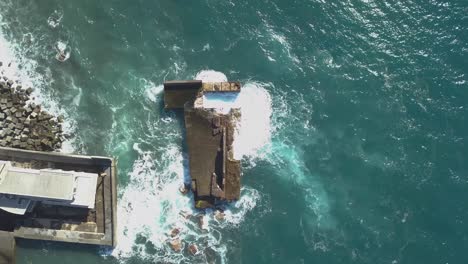 Aerial-view-of-the-waves-destruction-on-the-deactivated-marina-of-Lugar-de-Baixo,-Ponta-do-sol,-Madeira-Ísland,-Portugal