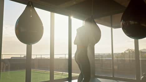 gym, woman and boxer punching bag for martial arts