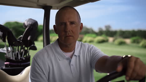 Man-sit-golf-cart-on-summer-course.-Luxury-player-looking-camera-at-country-club