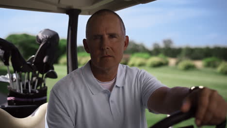 man sit golf cart on summer course. luxury player looking camera at country club