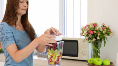 mujer sonriente haciendo un batido