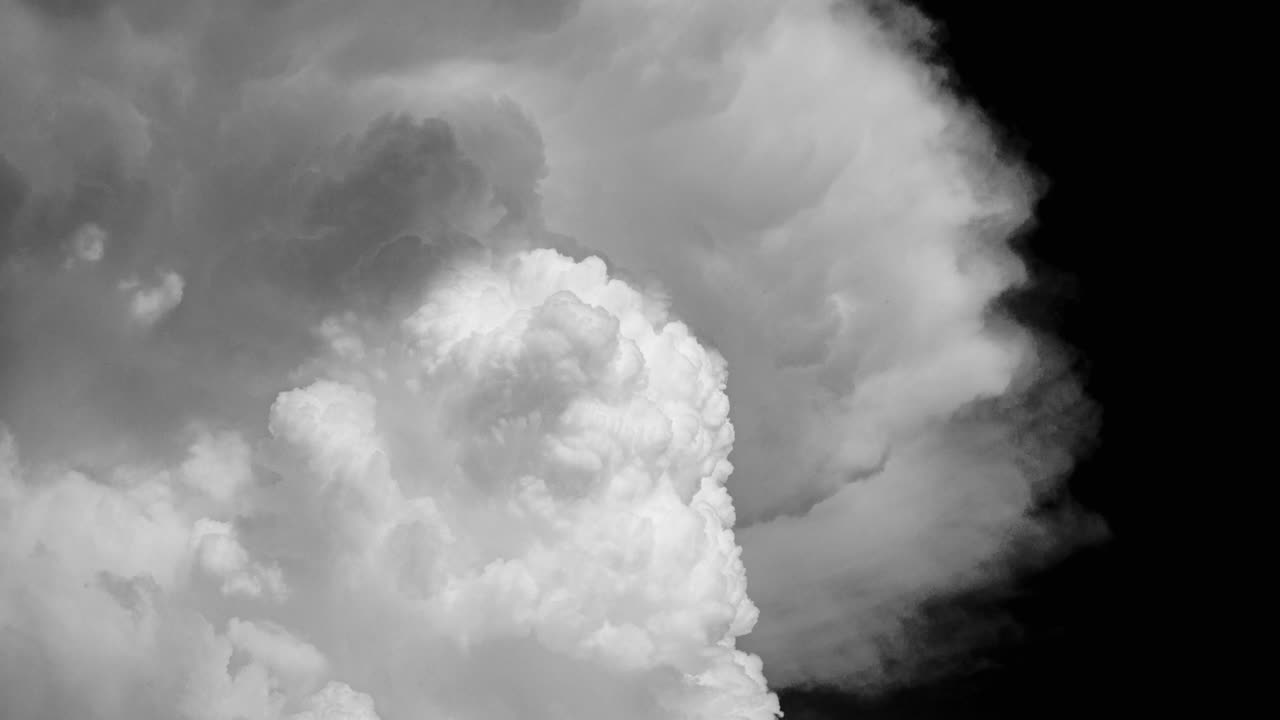 검은 하늘 배경의 타임스 영상에 구름 같은  연기가 있습니다.