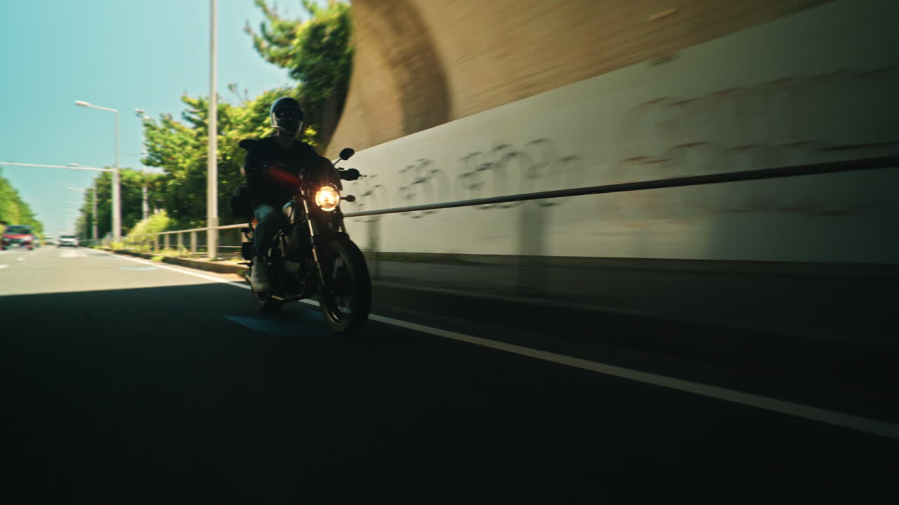Motociclista alla guida su strada