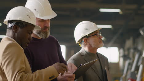 businessmen having factory tour with female manager