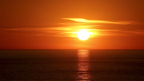 timelapse dramático de la puesta del sol en una playa entre algunas nubes en cascais