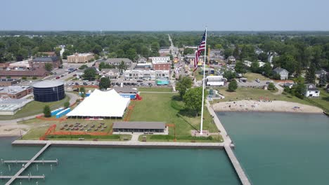 iconic american town with waving flag near lake, aerial drone view