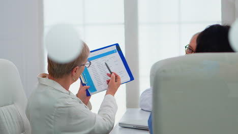 el médico anciano está haciendo una tormenta de ideas para discutir temas médicos.