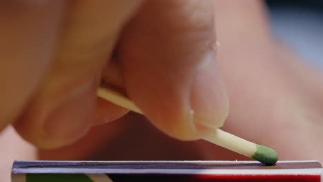 closeup of hand demonstrating how to light a match