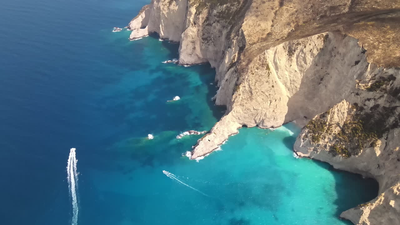 Aerial drone view of the Ionian Sea coast of Zakynthos, Greece. Rocky ridge, floating boats, blue water