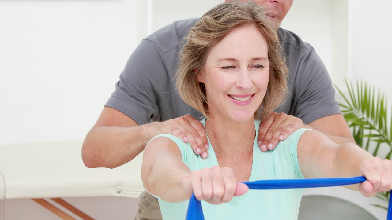 fisioterapeuta chequeando el paciente estirando la banda de resistencia