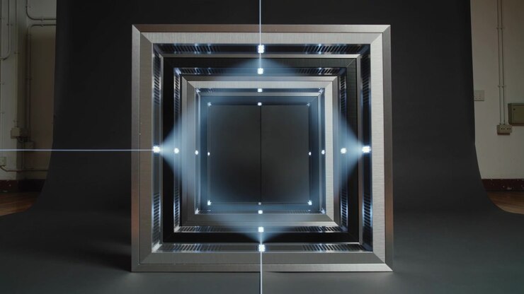Fascio di luce che attraversa il centro, creando una foschia a diamante, cornici metalliche annidate che catturano i LED sul drappo dello studio