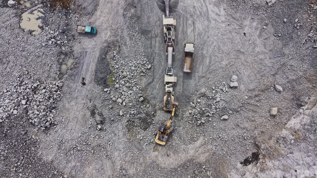 Aerial View of Excavator Loading Rocks onto Conveyor Belt in Quarry