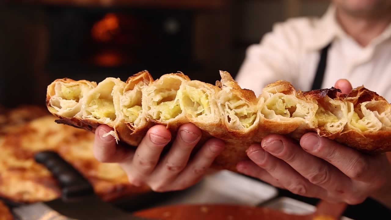 Chef Holding Freshly Baked Savory Pastry with Golden Crust