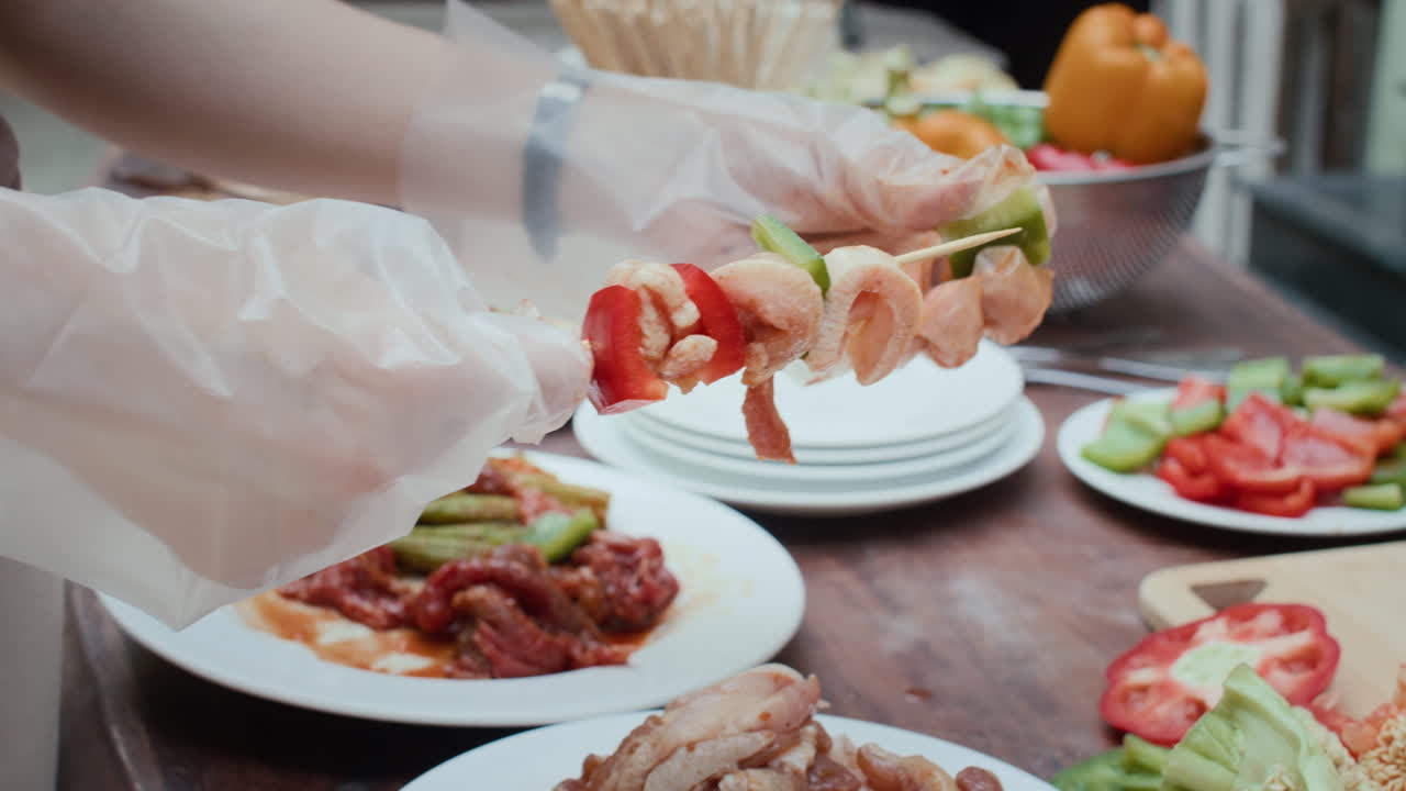 Hand of Person Skewering Meat and Vegetables Outdoors