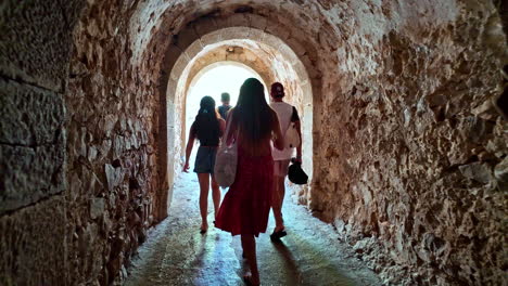 people walking through an old tunnel