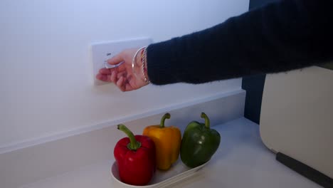 female-model-turning-on-then-off-a-white-cooker-switch-in-a-kitchen