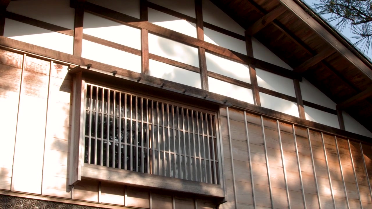 Traditionel japansk husfacade med trævindue og bevægelige skygger